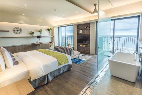 a bedroom with a bed and a bath tub and a sink at Kadda Hotel in Hualien City