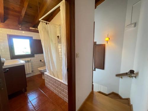 a bathroom with a sink and a toilet and a window at VILLA ISABEL in Piloña