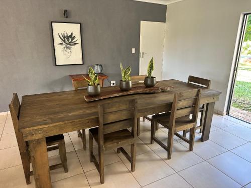 a wooden dining room table with plants on it at ValView Guest Lodge in Thabazimbi