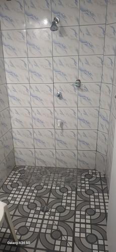 a bathroom with a shower with a tile floor at VureVure Homestay in Mbouma