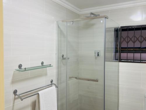 a bathroom with a shower with a glass door at Goshen villas in Mbabane