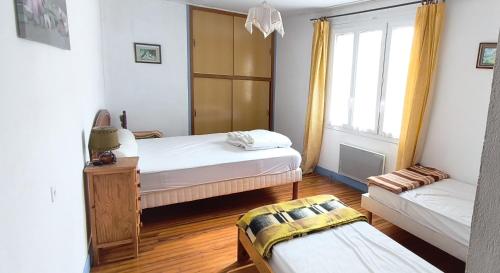 a small bedroom with two beds and a couch at la tute de l'ours in Roquefeuil