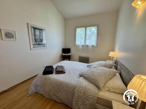 a bedroom with a bed and two windows at Entre mer et village in Leucate
