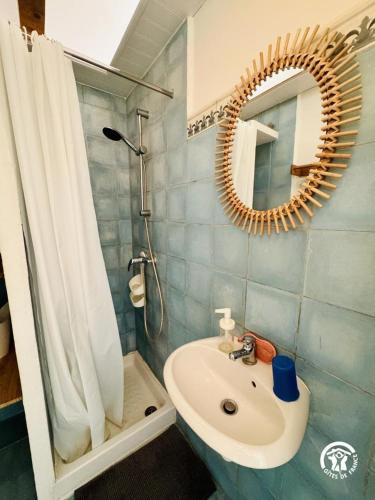 a bathroom with a sink and a mirror and a shower at Entre mer et village in Leucate