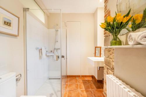 a bathroom with a shower and a vase of flowers at Petit Ca l'Andorrà in Vila-Sana