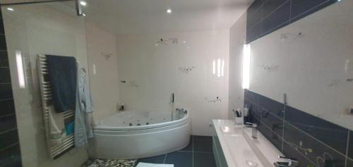 a white bathroom with a tub and a sink at Clos Pimi in Monbazillac