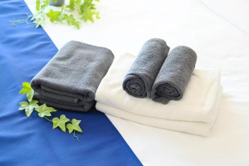 two towels sitting on top of a bed at Haniwa Stay Josai in Nagoya