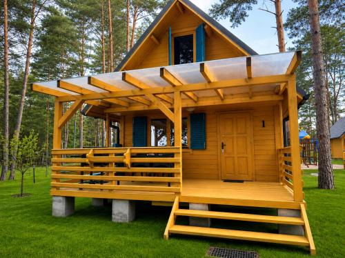a tiny house with a porch and a roof at Nartówka in Narty