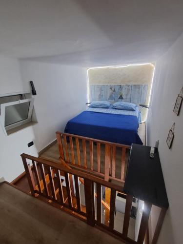 a bedroom with a bed with blue sheets and a table at Il Faro Suites in Taranto