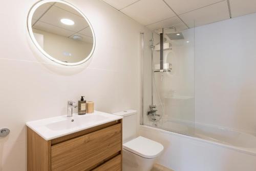 a bathroom with a sink and a toilet and a mirror at Casa Arena Rosa in Jávea