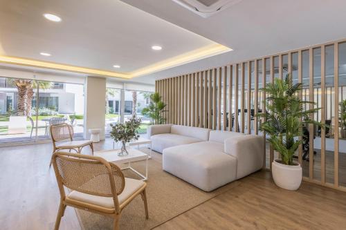 a living room with a white couch and chairs at Casa Arena Rosa in Jávea