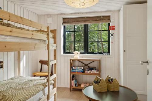 a bedroom with two bunk beds and a table at Nordic Nature Hideaway in Yderby