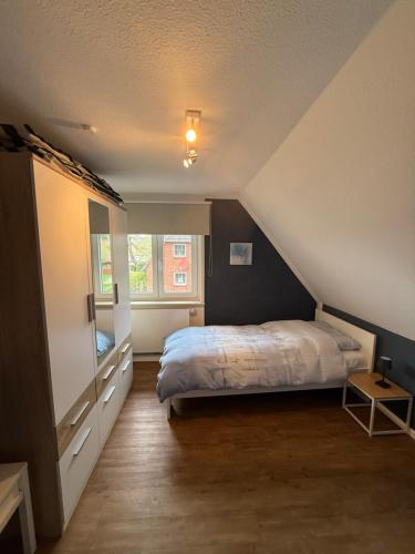a attic bedroom with a bed and a window at Ferienhaus SPO 54 grad in Böhl