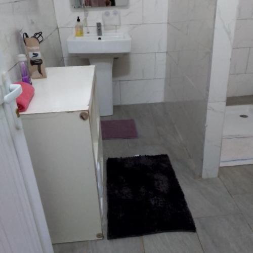 a white bathroom with a sink and a shower at VILLA Moissuli maison entière confortable avec Starlink in Mtsamboro