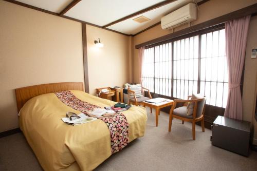 a hotel room with a bed and a table and chairs at お宿玄河 in Minamioguni
