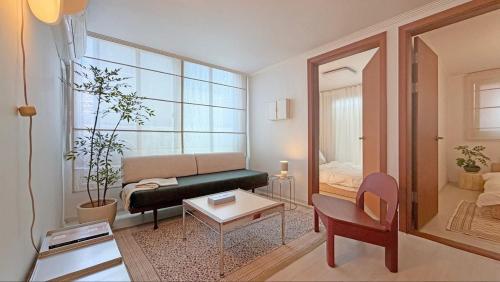 a living room with a couch and a mirror at SOYO-SOOP Stay in Seoul