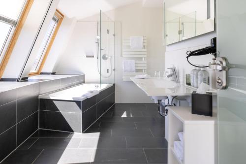 a bathroom with two sinks and a shower at THE GRAND Ahrenshoop in Ahrenshoop