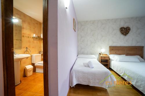 a bedroom with a bed and a bathroom with a sink at Casa Es Neres in Les