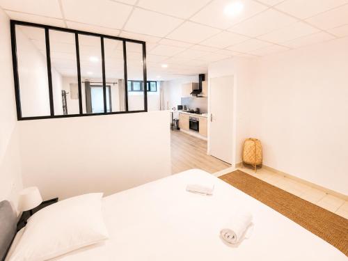 a bedroom with a white bed and a large window at Studio des quais in Saint-Aignan