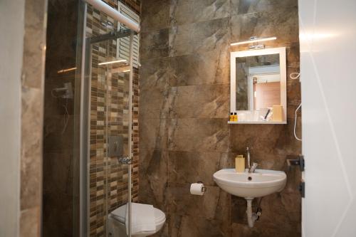 a bathroom with a sink and a toilet and a mirror at Quatro Life Hotel in Bodrum City