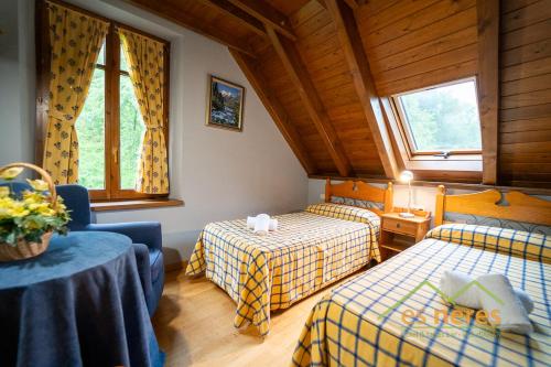 a room with two beds and a table and windows at Casa Es Neres in Les