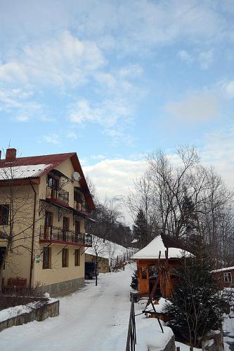a building with snow on the ground in front of it at Hovanka in Yaremche