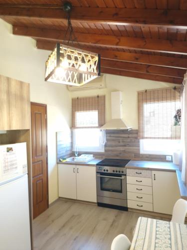 a kitchen with white cabinets and a stove top oven at komi's family house in Kómi