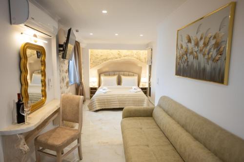 a bedroom with a bed and a couch in a room at Cosmopolitan Suites in Parga