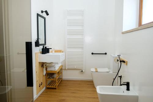 a bathroom with a sink and a toilet and a mirror at Dolcevita guest house in Torreano