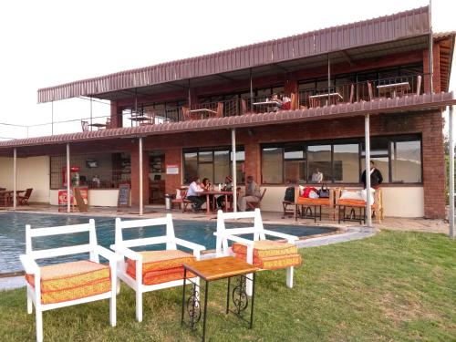 a group of chairs sitting in front of a building at Mwanzo Lodge in Naivasha