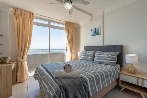 a bedroom with a bed and a large window at Cozumel 216 in Umdloti