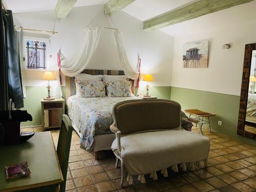 a bedroom with a bed and a chair at Mas Lou Piastoun in Fayence