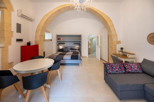 a living room with a couch a table and a bed at Kore in Noto