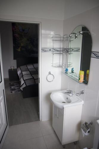 a white bathroom with a sink and a mirror at Villa Borboleta in Santana