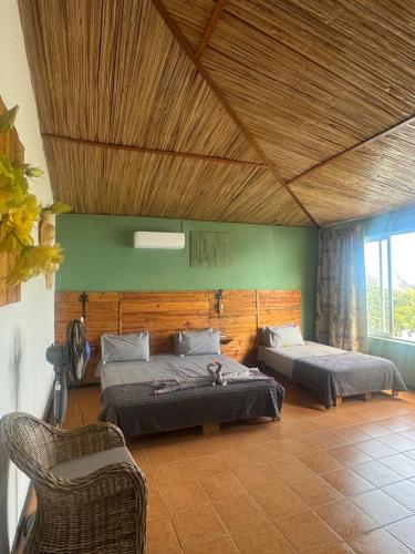 a bedroom with two beds and a chair in it at Bon Vivant Front de Mer - Ile Rodrigues in Rodrigues Island