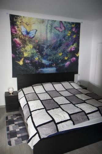 a bed in a room with a painting on the wall at Villa Borboleta in Santana