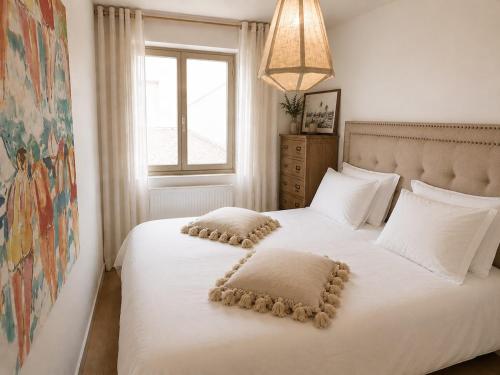 a bedroom with a white bed with pillows and a window at Le Touquet Beach, Front de Mer & Garage in Le Touquet-Paris-Plage