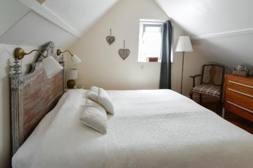 a bedroom with a large white bed in a attic at Cottages Croix Abbé, Bergeronnette in Saint-Valéry-sur-Somme
