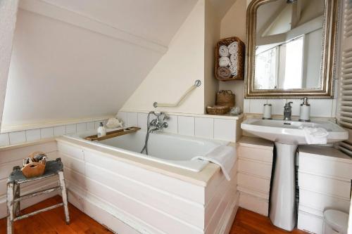 a white bathroom with a tub and a sink at Cottages Croix Abbé, Bergeronnette in Saint-Valéry-sur-Somme