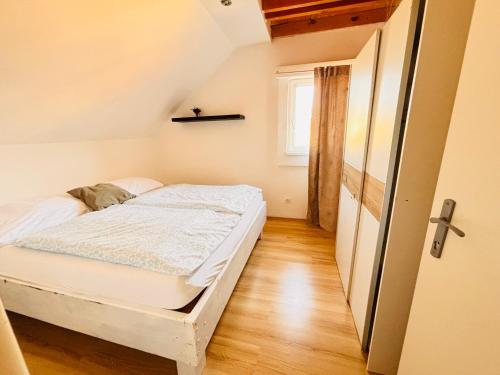 a small bedroom with a bed and a window at Apartmán Pura Vida in Zaječí