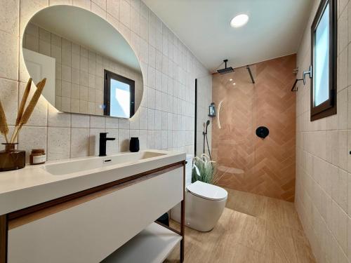 a bathroom with a sink and a toilet and a mirror at Casa Pilara Alojamiento rural in Callosa de Segura