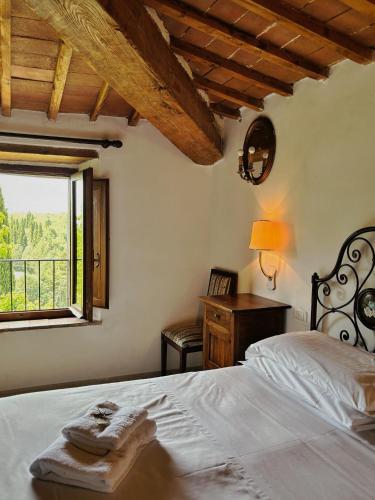 a bedroom with a white bed and a window at Hotel Casafrassi in Castellina in Chianti
