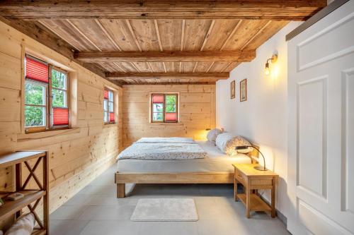 a bedroom with a bed in a wooden house at Ferienwohnung Lausche in Hörnitz