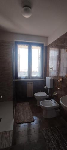 a bathroom with two toilets and two sinks and a window at Casa Alice, in collina con panorama in Lonato