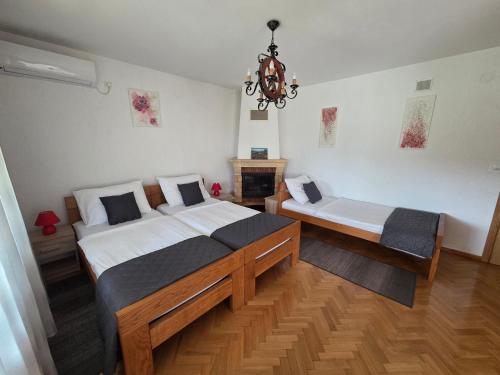 a bedroom with two beds and a chandelier at House Bogović in Karlovac
