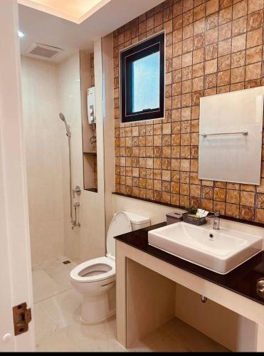 a bathroom with a white toilet and a sink at บ้านประภัสราคม โฮมสเตย์ นครสวรรค์ in Ban Ko Ta Thep