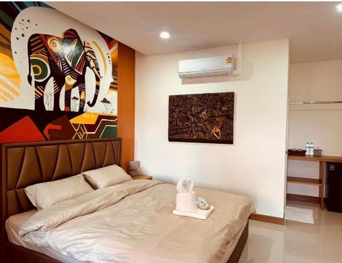 a bedroom with a bed and a painting on the wall at บ้านประภัสราคม โฮมสเตย์ นครสวรรค์ in Ban Ko Ta Thep
