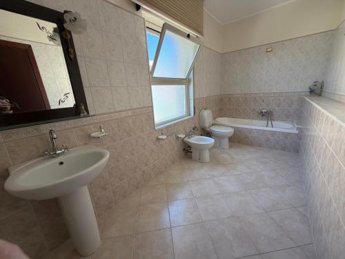 a bathroom with a sink and a toilet and a tub at Villa Aurea in Avola