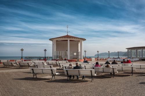 a group of people sitting on benches in front of a building at Hotel Villa Belvedere in Binz