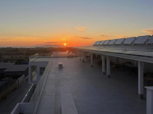 a view of a building with the sunset in the background at Dara Holiday Apartments in Marsala